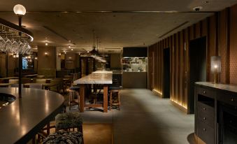 a dimly lit restaurant with a long dining table and several chairs arranged around it at Nohga Hotel Akihabara Tokyo