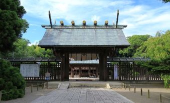 a large wooden gate in front of a building , possibly a temple or a shrine at Art Hotel Miyazaki Sky Tower