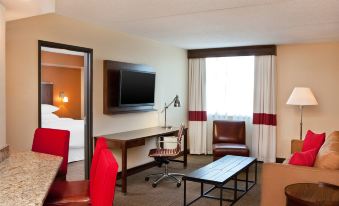 a hotel room with a bed , a desk , a chair , a television , and a television in the corner at Four Points by Sheraton Saginaw