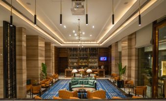a large hotel lobby with a check - in desk and a seating area , featuring comfortable chairs and a television at Crowne Plaza New Delhi Mayur Vihar Noida