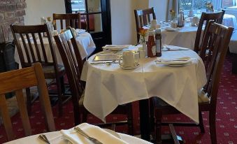 a dining room with tables and chairs arranged for a group of people to enjoy a meal together at The Swan Hotel