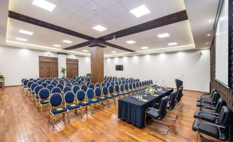 a large conference room with rows of chairs and tables , a projector screen , and a podium at Marina Bay City Center