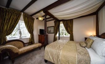 a bedroom with a bed , couch , and window curtains , featuring a chandelier and large window at The Bear Inn