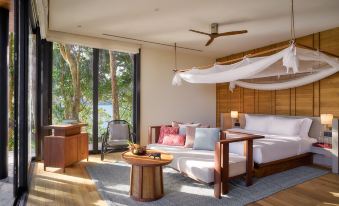a luxurious bedroom with a large bed , a couch , and a dining table in the room at Six Senses Krabey Island