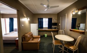 a small , cozy apartment with a dining table and chairs , a couch , and a refrigerator at Ardeanal Motel