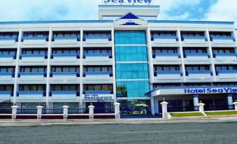 "a large building with a blue sign that says "" sea view "" has white columns in front of it" at Hotel Sea View