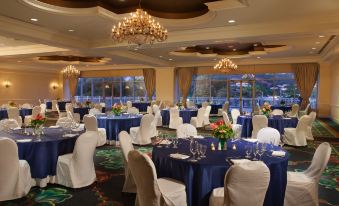 a large banquet hall filled with tables and chairs , all set for a formal event at St. Kitts Marriott Resort & the Royal Beach Casino