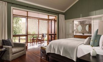 a bedroom with a large bed and sliding glass doors leading to an outdoor patio at Emirates One&Only Wolgan Valley