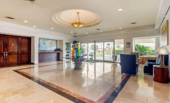 a large , well - lit room with marble flooring and a chandelier hanging from the ceiling , as well as a reception area and a desk at Quality Inn Monterrey la Fe