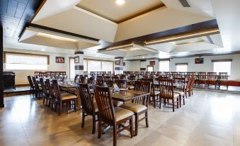 a large dining room with wooden tables and chairs arranged for a group of people to enjoy a meal together at Hotel Bella Vista
