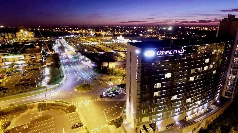 a large hotel with a crowne plaza sign on top of it , surrounded by a busy city at night at Crowne Plaza Dublin - Blanchardstown