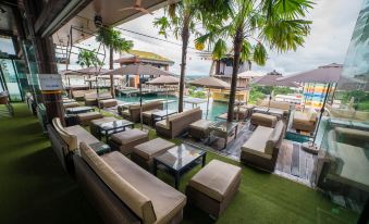 a rooftop patio with multiple lounge chairs and couches arranged around a pool , creating a relaxing atmosphere at ABC Hotel