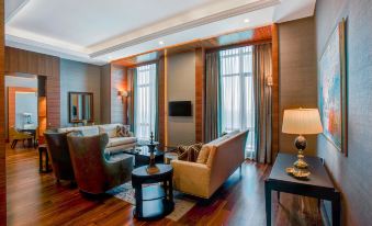 a spacious living room with wooden floors and furniture , including a couch , chairs , and a tv at Sheraton Grand Samsun Hotel