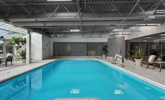 an empty indoor swimming pool surrounded by a building , with a staircase leading to the pool area at Hilton Chicago/Oak Lawn