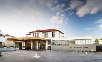 "a large building with a red roof and the words "" international on the water hotel "" written above it" at Swan River Hotel