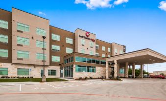 "a large building with a red sign that reads "" best western plus "" in front of it" at Best Western Plus Executive Residency Austin