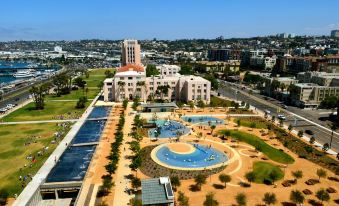 an aerial view of a city with a large building and a pool surrounded by grass at Wyndham San Diego Bayside