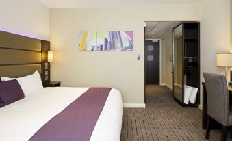 a modern hotel room with a white bed , purple accent rug , and a large painting above the bed at Premier Inn Bagshot
