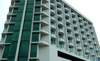 "a modern building with a white exterior and green glass windows , featuring the name "" principe "" in black letters on top" at Hotel Principe