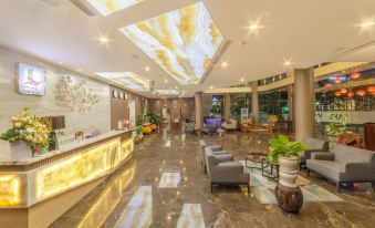 a large hotel lobby with high ceilings , marble floors , and a reception desk where guests can enter and socialize at Lake View Hotel