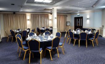 a large dining room with blue chairs and tables set up for a formal event at Royal Maritime Hotel