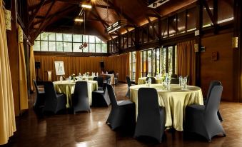 a large dining room with tables and chairs set up for a formal event , possibly a wedding reception at Horison Green Forest Bandung