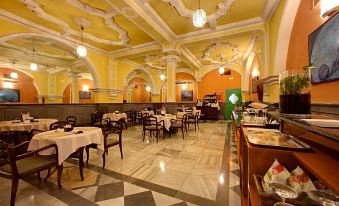 a large , ornate dining room with multiple tables and chairs arranged for a group of people at Hotel Inglaterra