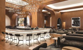 a modern lounge area with a bar and various seating options , including couches and chairs at Signia by Hilton San Jose