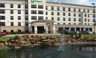 a large hotel with a fountain in front of it and a sign on the building at Holiday Inn Carbondale-Conference Center