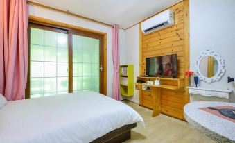 The middle room features a double bed, wooden doors, and a large window at Gapyeong Dasom Pension