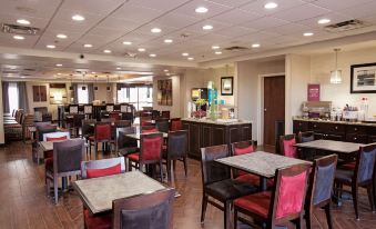 a large dining area with multiple tables and chairs , a counter , and a reception desk at Hampton Inn Moultrie