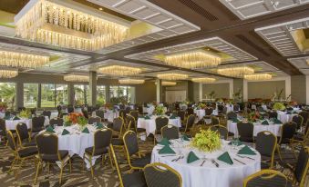 a large banquet hall filled with round tables and chairs , ready for a formal event at OUTRIGGER Kaua'i Beach Resort & Spa