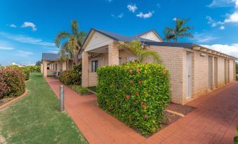 a row of houses with brick pavers on the ground , surrounded by trees and bushes at Comfort Inn & Suites Karratha