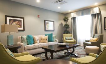 a cozy living room with a beige couch , two chairs , and a coffee table in the center at Homewood Suites by Hilton Hamilton