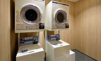 two washing machines are stacked on top of each other in a room with wooden walls at Fairfield by Marriott Tochigi Utsunomiya
