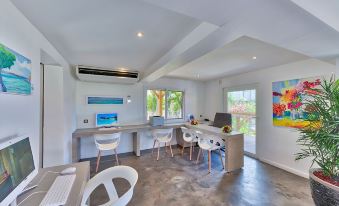 a modern home office with white furniture , a blue air conditioner , and large windows , under a concrete floor at Grand Case Beach Club