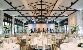 a large , elegant banquet hall with white tablecloths , chairs , and a chandelier hanging from the ceiling at Omni Barton Creek Resort and Spa Austin