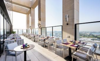 an outdoor dining area with tables and chairs arranged for a group of people to enjoy a meal at Park Hyatt Doha