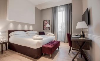 a hotel room with a large bed , desk , and window , creating a comfortable and elegant atmosphere at Palazzo Castri 1874 Hotel & Spa