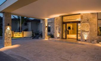 a large , modern building with a stone facade and an open doorway leading to another building at Blue Bay Halkidiki