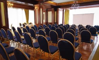 a large conference room with rows of chairs arranged in a semicircle , ready for an event at Hotel Roman by Dumbrava Business Resort