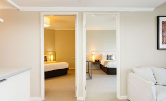 a hotel room with two beds , one on the left and one on the right side of the room at The Marina Hotel - Mindarie