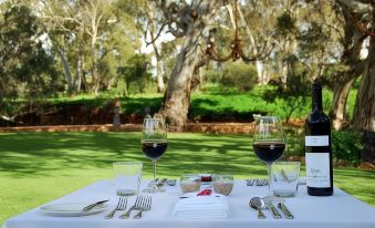a dining table set for a formal dinner , with two wine glasses and silverware arranged on the table at Jacobs Creek Retreat
