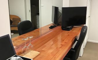 a wooden desk with a mirror on it , surrounded by office supplies and other items at Black Forest Motel