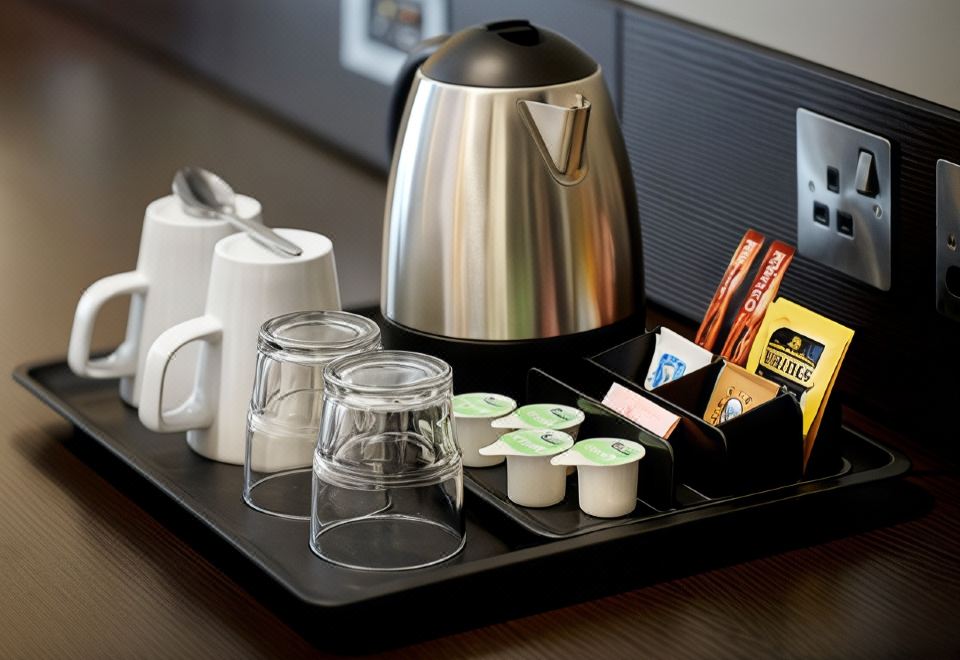 a black tray with a silver electric kettle , cups , and other items on it , placed on a table in a room at Thirsk