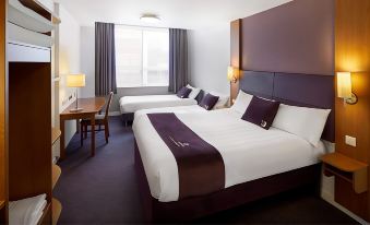 a hotel room with two beds , a desk , and a window , all decorated in white and brown at Premier Inn Burton On Trent East