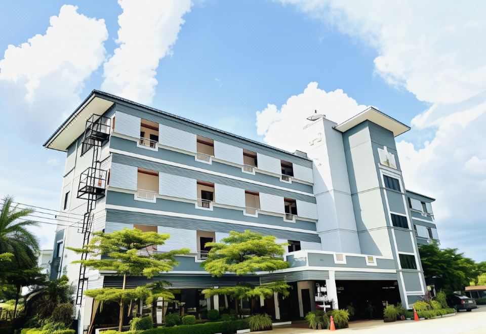 a large , modern building with multiple floors and balconies , surrounded by lush greenery and blue sky at Thatphanom View Hotel