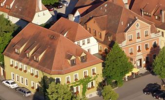 a bird 's eye view of a city with red - roofed buildings and trees , including a large tree at Akzent Hotel Schranne