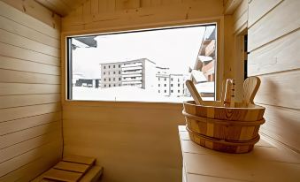 a wooden bench is placed in front of a window with a view of buildings at Avenue Lodge Hotel & Spa