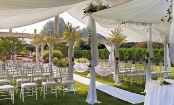 a white wedding ceremony setup under a canopy of white drapes , with chairs arranged for guests at Westminster Hotel